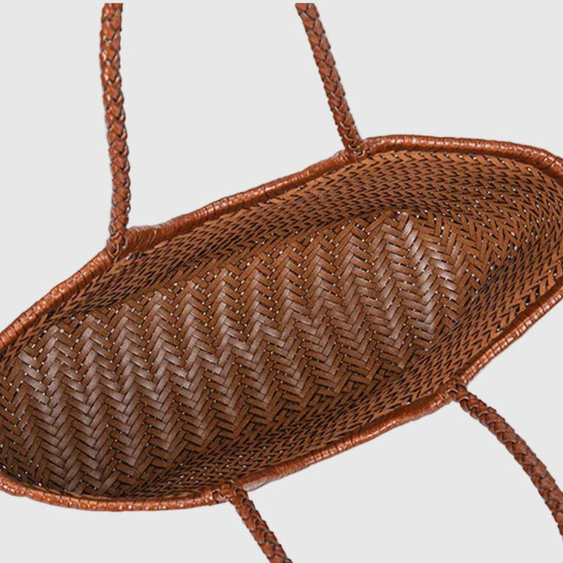 Brown woven basket with a handle on a light gray background