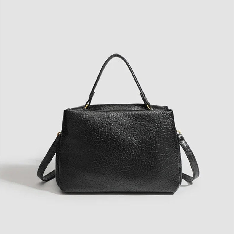 Black handbag on a light gray background