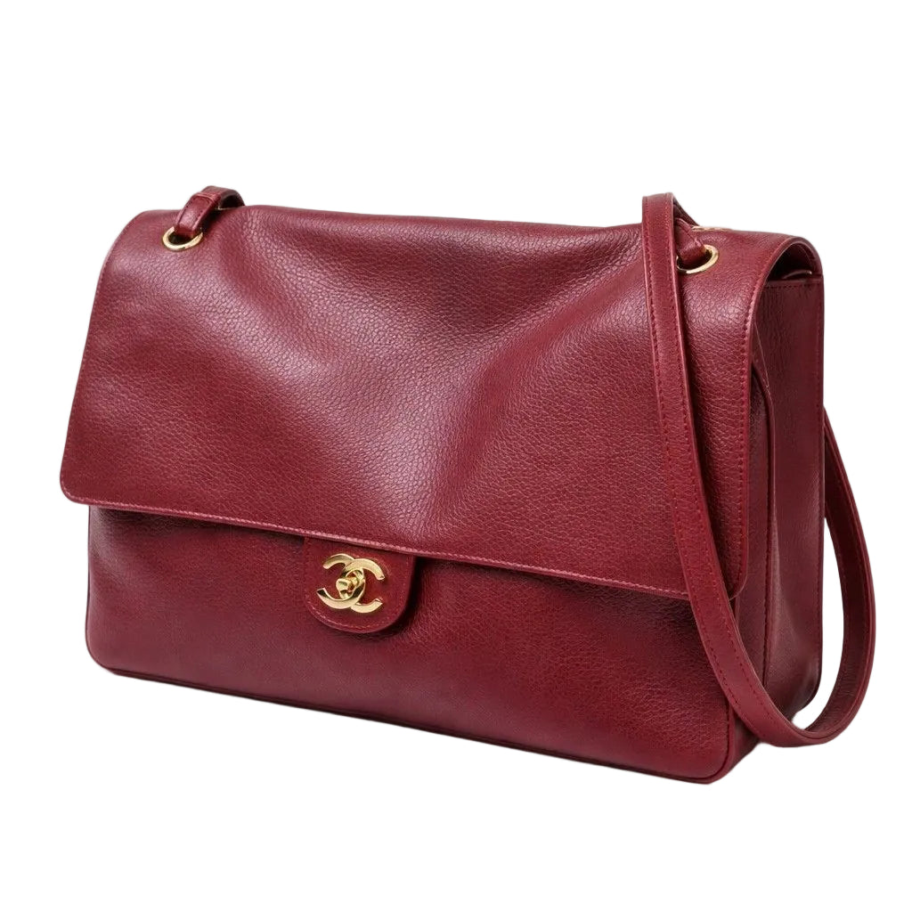 Burgundy leather handbag with gold hardware on a white background