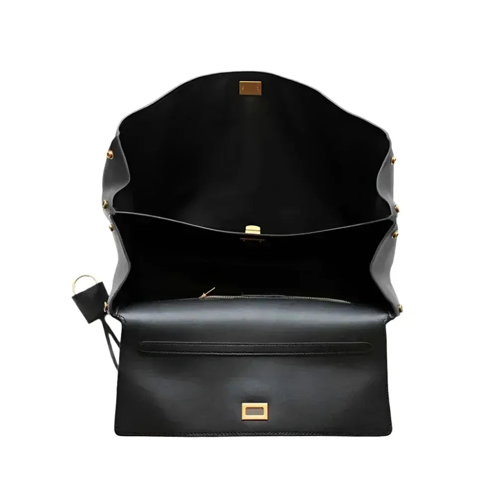 Black leather handbag with gold accents on a white background
