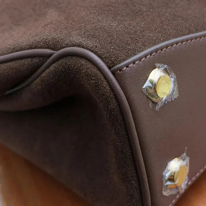 Close-up of a brown leather bag with gold studs.