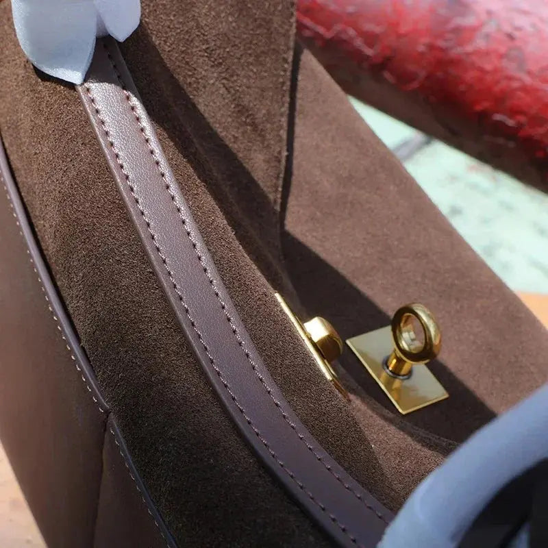 Close-up of a brown leather bag with a gold clasp