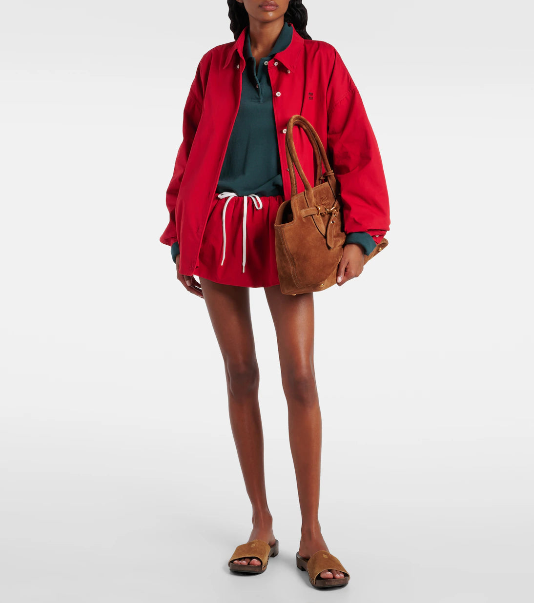 Person wearing a red jacket and shorts with a brown bag on a white background